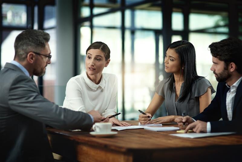 Group of people around a table in a board room