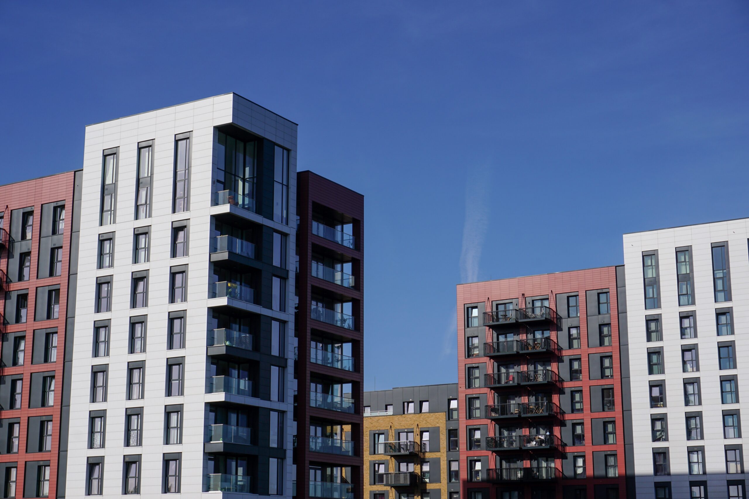 Modern high-rise residential building with bright blue sky